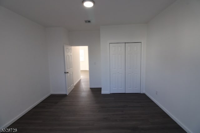 unfurnished bedroom featuring dark hardwood / wood-style floors and a closet