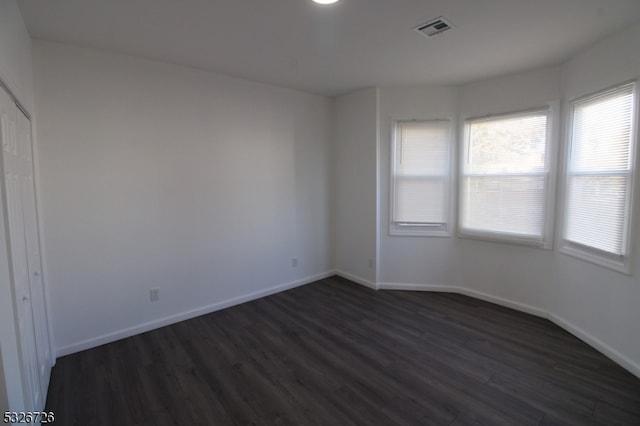 spare room with dark hardwood / wood-style flooring