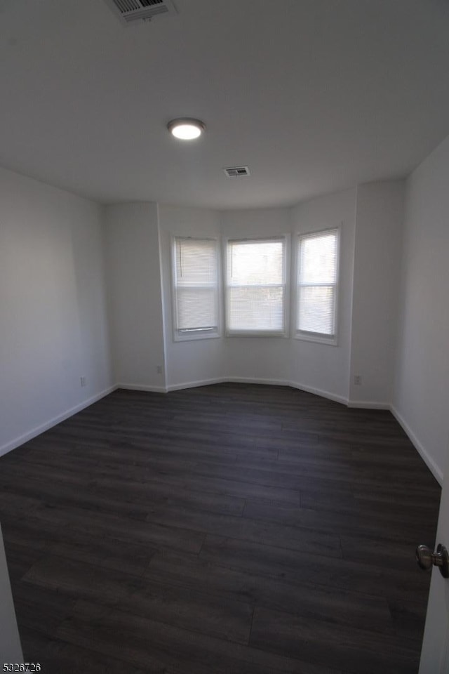 empty room featuring dark hardwood / wood-style flooring