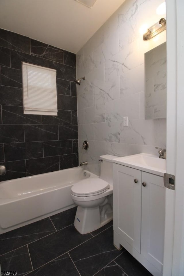 full bathroom featuring toilet, vanity, bathing tub / shower combination, and tile walls