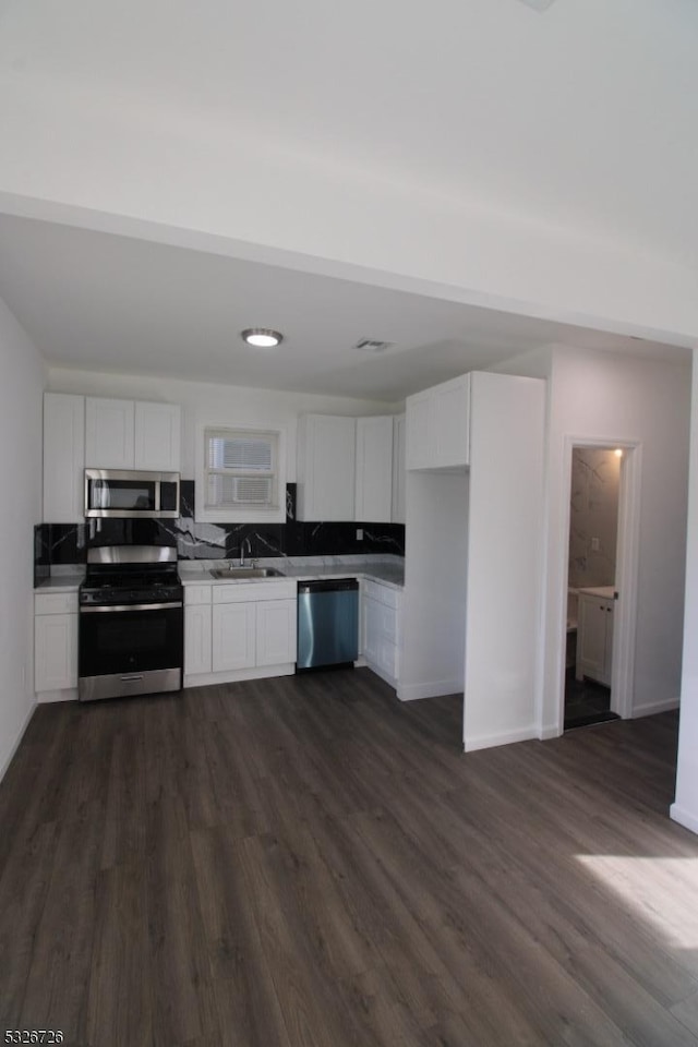 kitchen with sink, white cabinetry, dark wood-type flooring, and appliances with stainless steel finishes