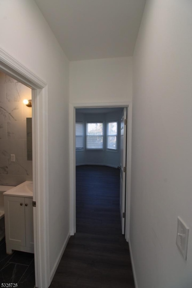 corridor featuring dark hardwood / wood-style floors and tile walls