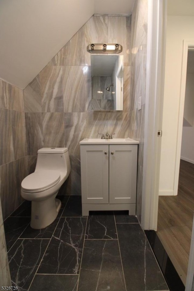 bathroom with wood-type flooring, vanity, toilet, and tile walls