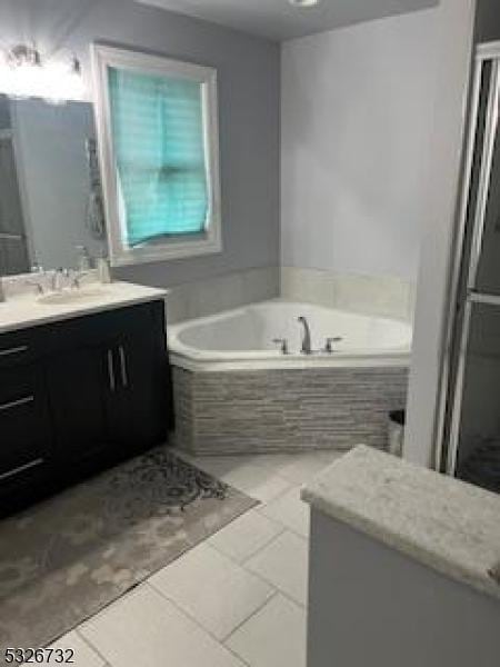 bathroom featuring vanity, tiled bath, and tile patterned floors