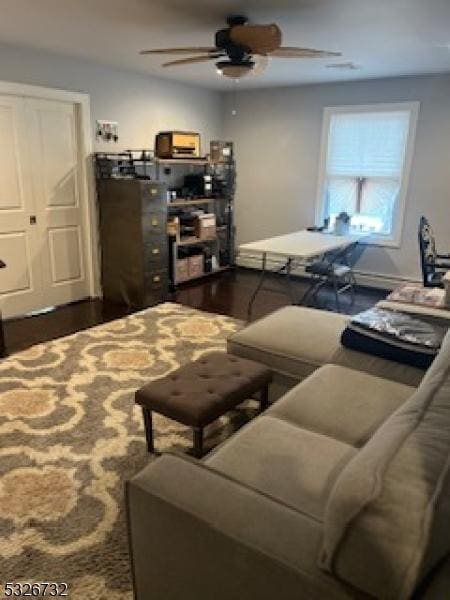 living room with dark hardwood / wood-style flooring and ceiling fan