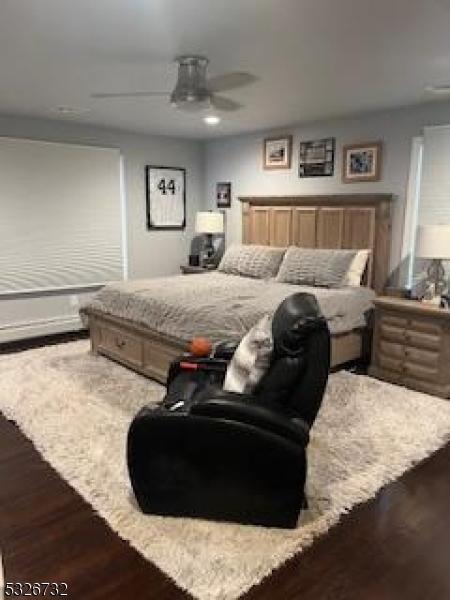 bedroom with dark hardwood / wood-style floors and ceiling fan