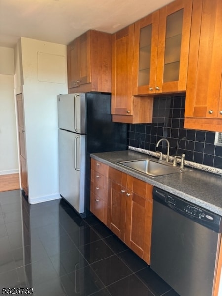 kitchen with decorative backsplash, stainless steel appliances, dark tile patterned flooring, and sink