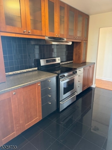 kitchen with stainless steel range with electric stovetop, dark tile patterned flooring, and tasteful backsplash