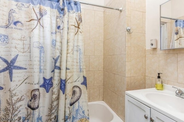 bathroom with tile walls, decorative backsplash, vanity, and shower / bath combo