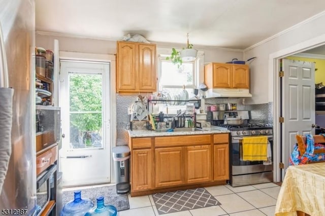 kitchen with tasteful backsplash, stainless steel gas range oven, ornamental molding, sink, and light tile patterned floors