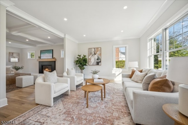 living room featuring light hardwood / wood-style flooring, beamed ceiling, and ornamental molding