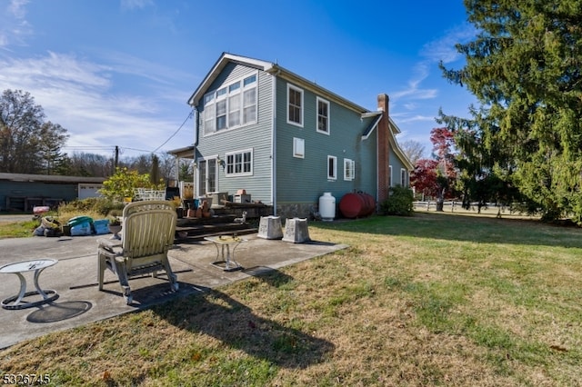 back of house with a patio area and a yard