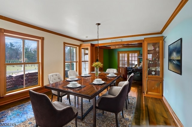 dining area with ornamental molding, dark wood-type flooring, and french doors