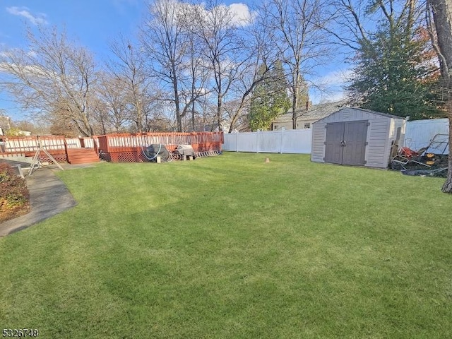 view of yard featuring a wooden deck and a storage unit