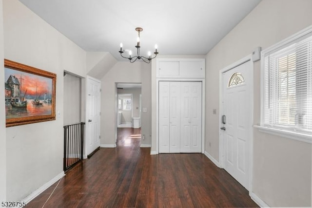 entryway with a notable chandelier, dark hardwood / wood-style floors, and plenty of natural light