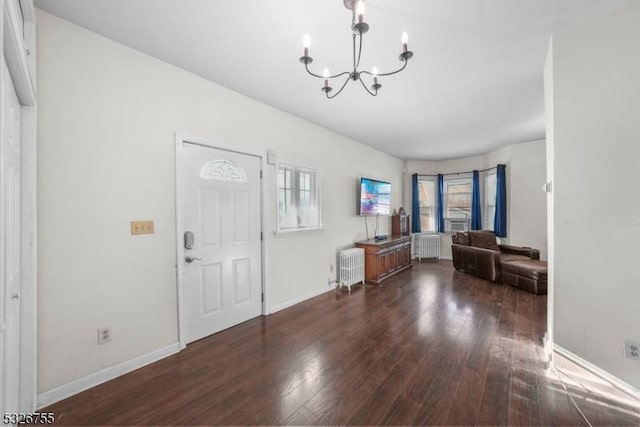 entryway featuring radiator heating unit, dark hardwood / wood-style flooring, and a notable chandelier