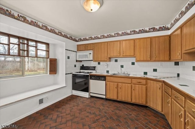 kitchen with sink, white appliances, and backsplash