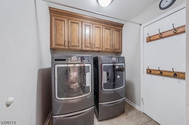 laundry room featuring light tile patterned flooring, cabinets, and independent washer and dryer