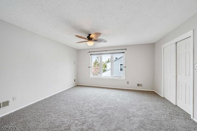 unfurnished bedroom with ceiling fan, a closet, carpet floors, and a textured ceiling