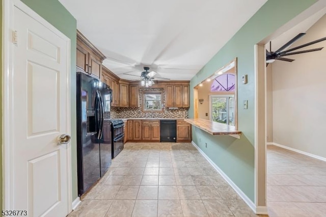 kitchen featuring kitchen peninsula, tasteful backsplash, ceiling fan, black appliances, and light tile patterned flooring