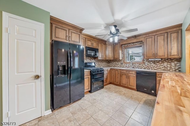 kitchen featuring backsplash, ceiling fan, sink, black appliances, and butcher block counters