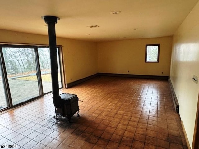 tiled spare room featuring a wood stove