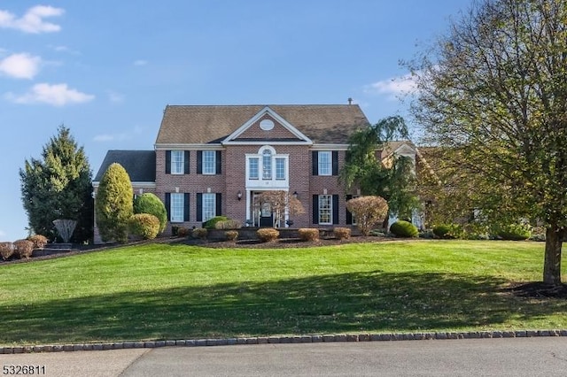 colonial-style house featuring a front yard