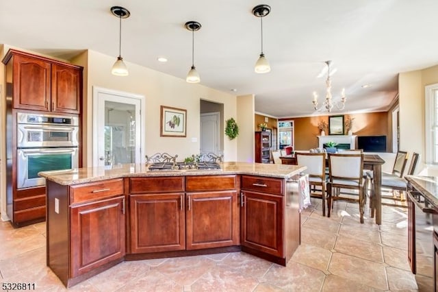 kitchen featuring a center island with sink, a notable chandelier, stainless steel appliances, and hanging light fixtures