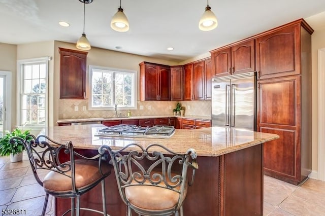 kitchen with a healthy amount of sunlight, hanging light fixtures, and stainless steel appliances