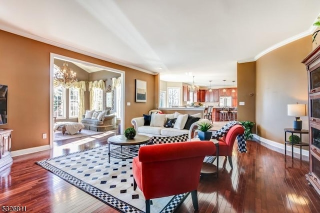 living room with ornamental molding, dark wood-type flooring, and a notable chandelier