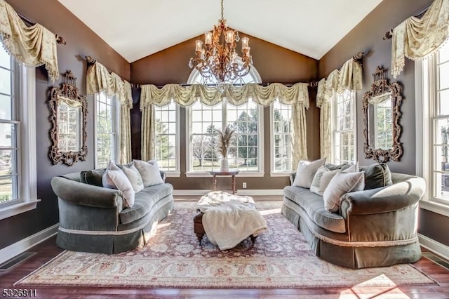 sitting room featuring a healthy amount of sunlight, lofted ceiling, and a chandelier