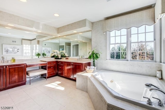 bathroom with tiled bath, tile patterned flooring, and vanity