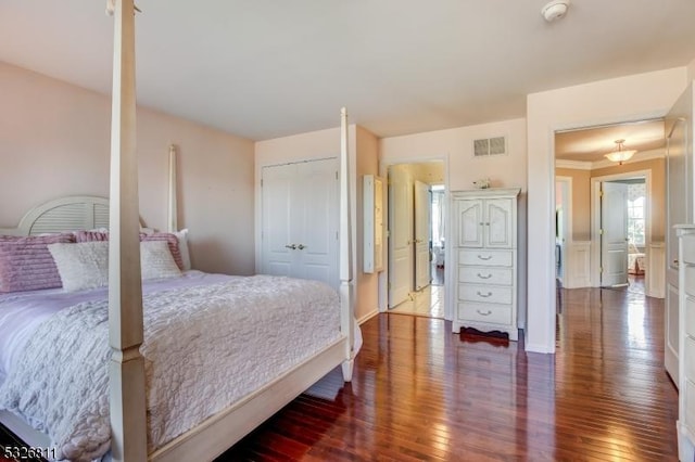 bedroom featuring hardwood / wood-style flooring, crown molding, and a closet