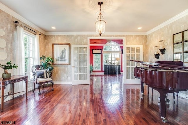 interior space featuring hardwood / wood-style flooring, a chandelier, crown molding, and french doors