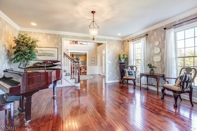 living area featuring a chandelier, crown molding, and wood-type flooring