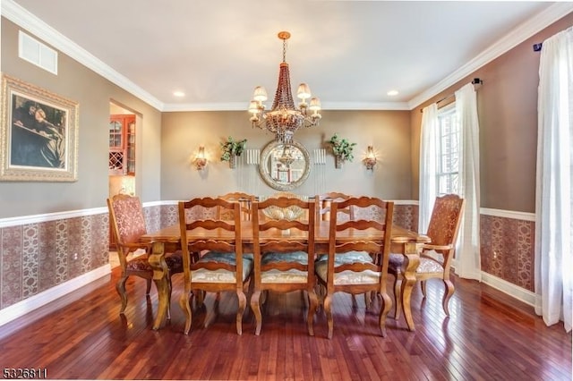 dining space with ornamental molding, dark wood-type flooring, and a chandelier