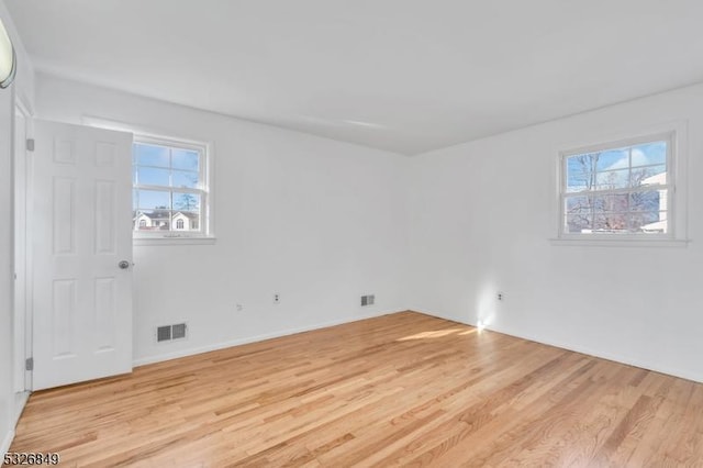 spare room with plenty of natural light and light wood-type flooring