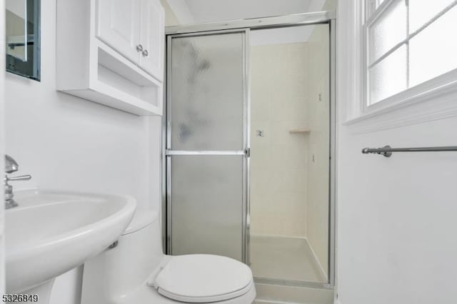 bathroom featuring toilet, walk in shower, and sink