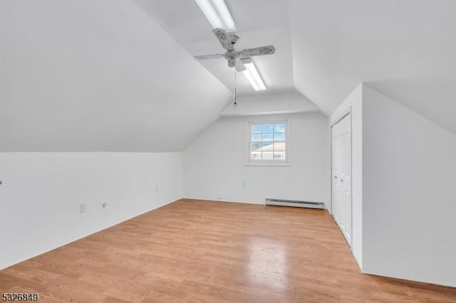 additional living space featuring ceiling fan, a baseboard radiator, lofted ceiling, and light hardwood / wood-style floors