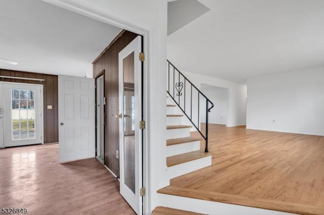 staircase featuring wood-type flooring and wood walls