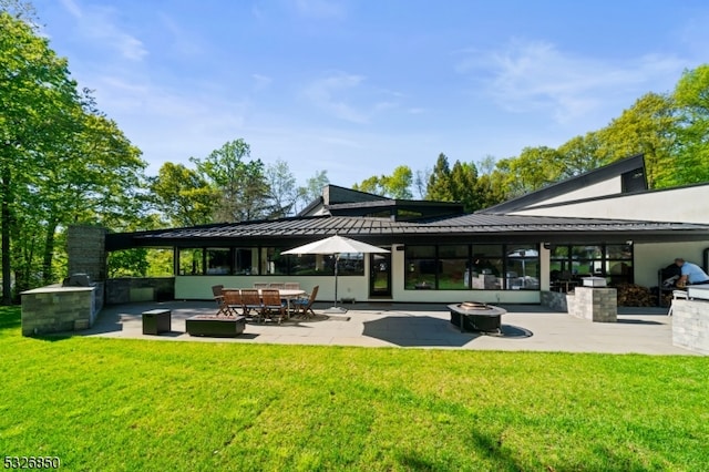 surrounding community featuring a patio area, a yard, exterior kitchen, and a fire pit