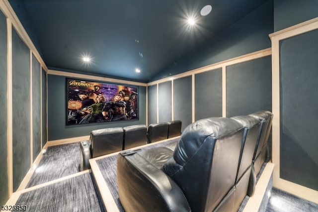 cinema room featuring carpet flooring and vaulted ceiling