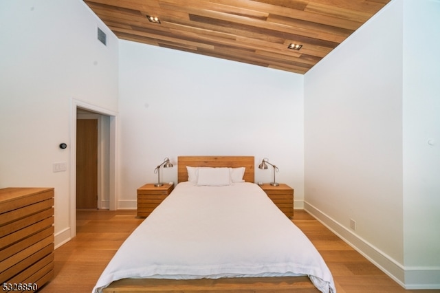 bedroom with high vaulted ceiling, light hardwood / wood-style flooring, and wooden ceiling