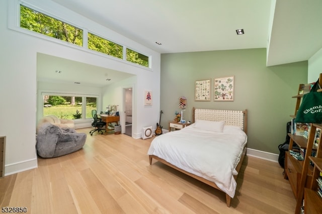 bedroom with hardwood / wood-style floors and high vaulted ceiling