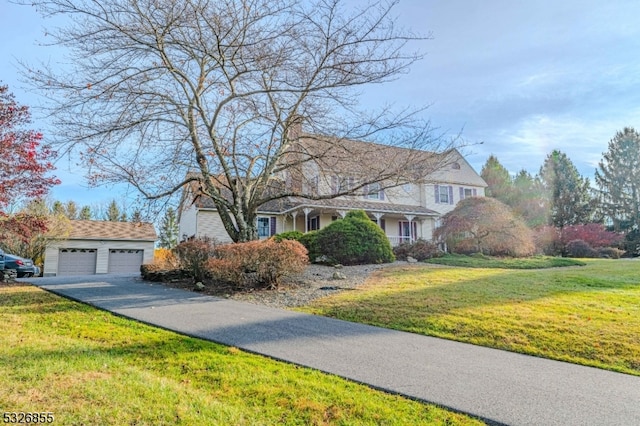 view of front of home with an outbuilding, a front lawn, and a garage