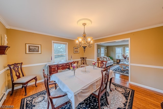 dining space featuring crown molding, plenty of natural light, and hardwood / wood-style floors