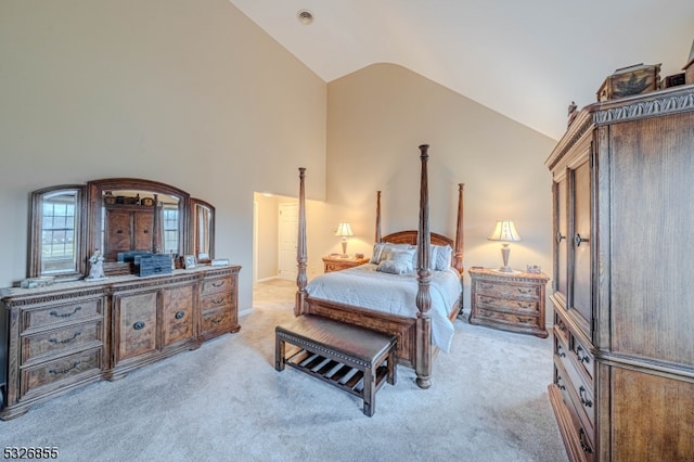 carpeted bedroom with high vaulted ceiling