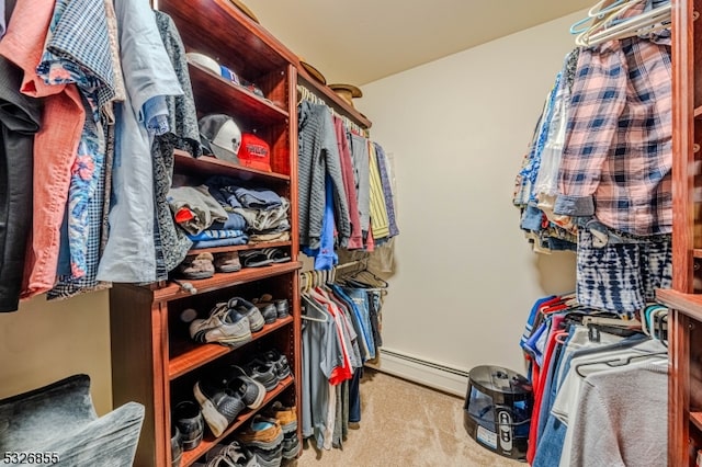 spacious closet featuring light colored carpet and a baseboard heating unit