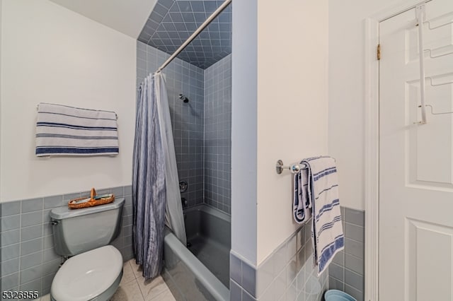 bathroom with tile patterned floors, toilet, tile walls, and shower / bath combo with shower curtain