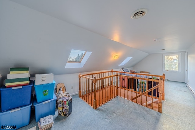 additional living space featuring carpet floors and vaulted ceiling with skylight